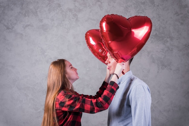 Pareja con globos en forma de corazón