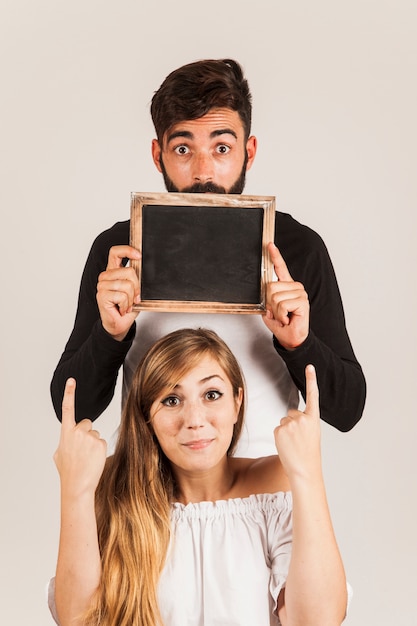 Foto gratuita pareja graciosa con pizarra