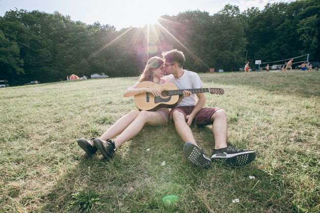 Pareja con una guitarra apunto de besarse