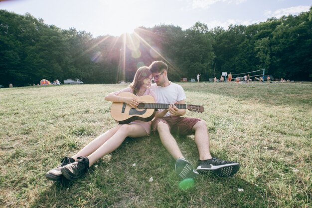 Pareja con una guitarra frente con frente