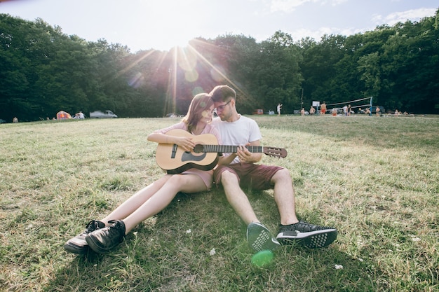 Pareja con una guitarra frente con frente