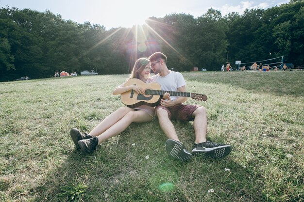 Pareja con una guitarra frente con frente