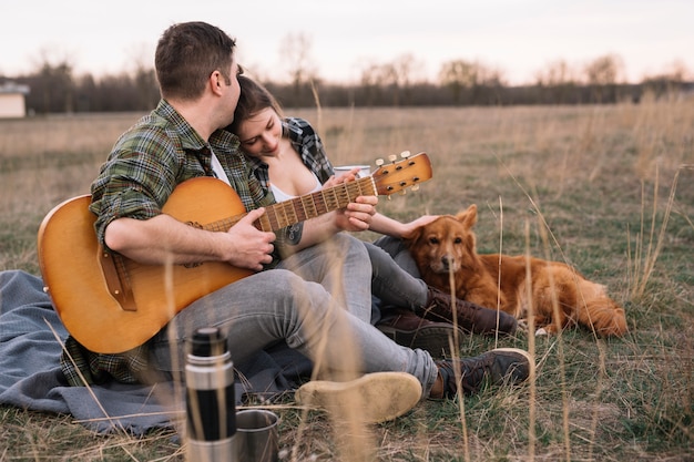 Pareja con guitarra y perro