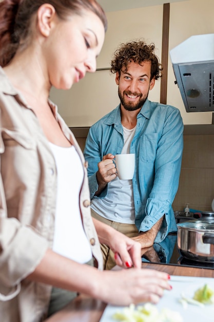 Pareja hablando mientras la esposa prepara la cena