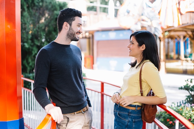 Foto gratuita pareja hablando en el parque de atracciones