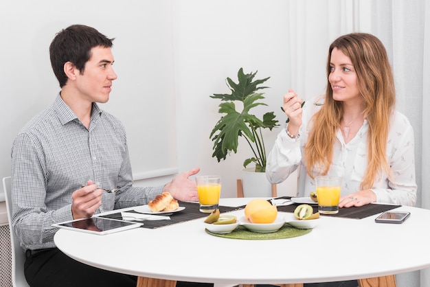 Pareja hablando sentado en la mesa