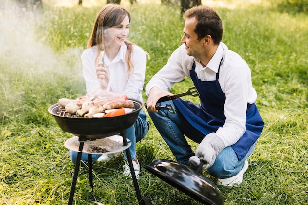 Pareja haciendo una barbacoa en la naturaleza