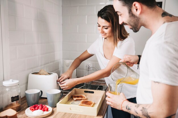 Pareja haciendo brindis y vertiendo jugo