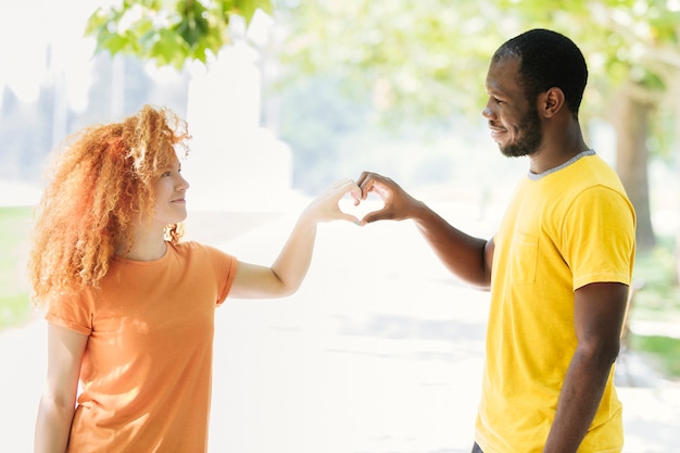 Foto gratuita pareja haciendo un corazón con sus manos