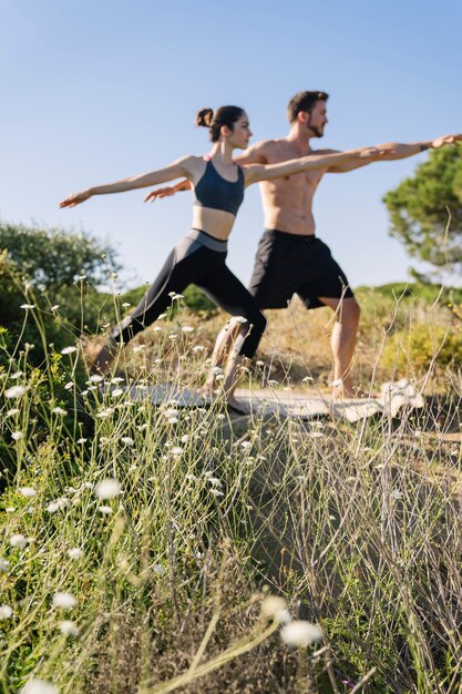 Pareja haciendo ejercicio de yoga en la playa