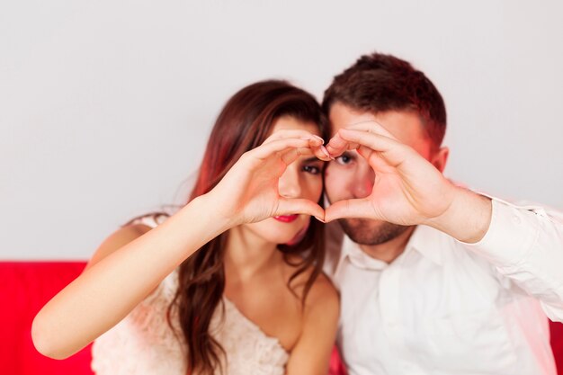 Pareja haciendo una forma de corazón con sus manos