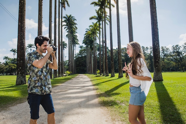 Pareja haciendo foto en camino de palmeras