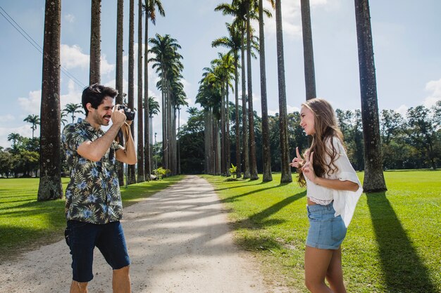 Pareja haciendo foto en camino de palmeras