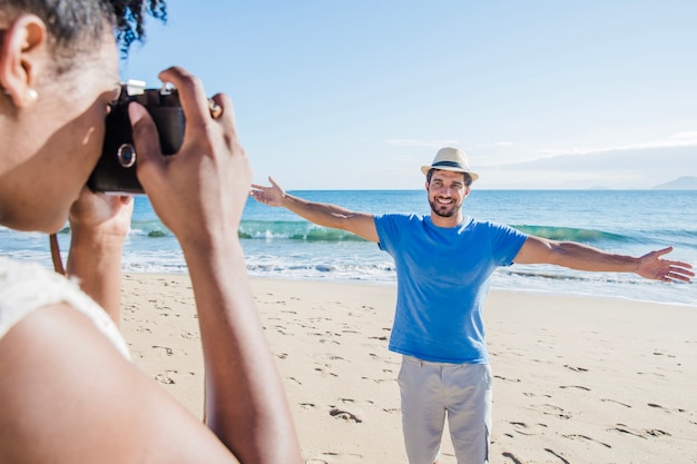 Pareja haciendo fotos uno al otro en la playa