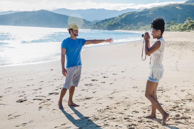 Pareja haciendo fotos en una playa hermosa