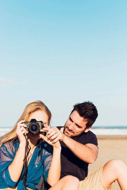 Foto gratuita pareja haciendo fotos en la playa