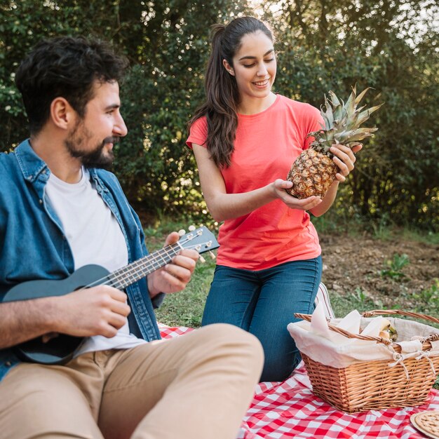 Pareja haciendo picnic con piña