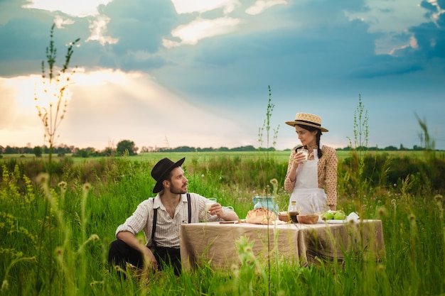 pareja haciendo un picnic en el prado