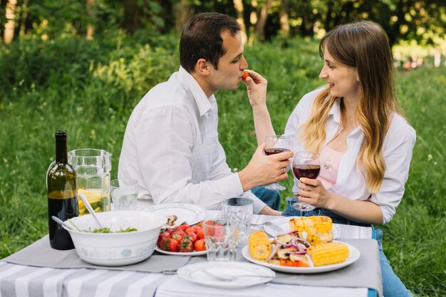 Pareja haciendo un picnic romántico en la naturaleza