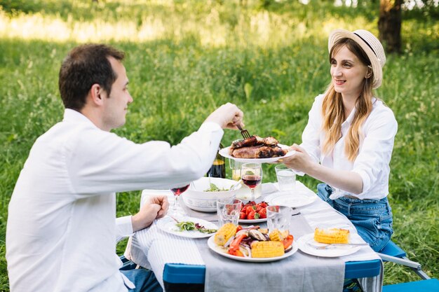 Pareja haciendo un picnic romántico en la naturaleza