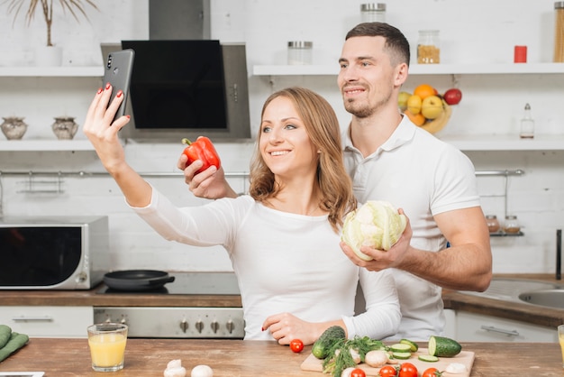 Pareja haciendo selfie en cocina