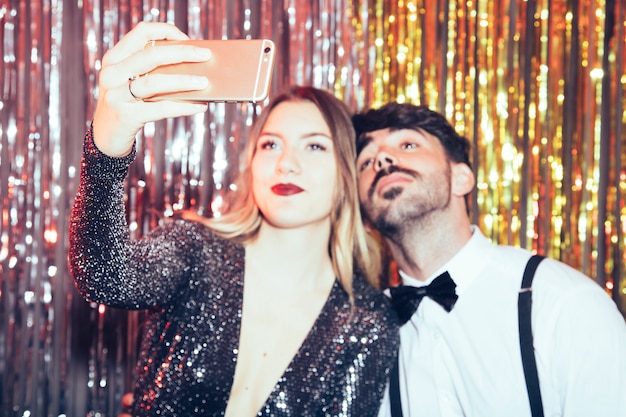 Pareja haciendo un selfie en fiesta de año nuevo