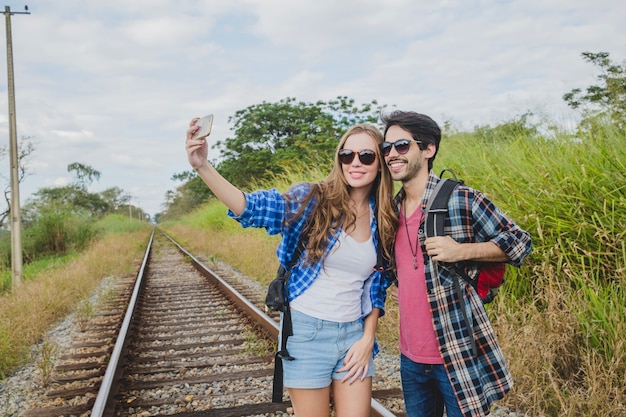 Foto gratuita pareja haciendo un selfie en vías de tren