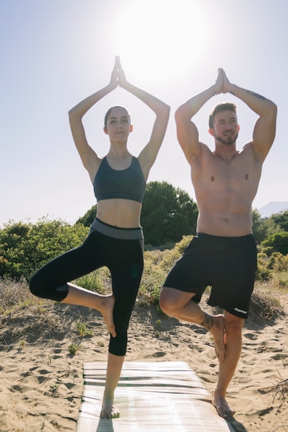 Foto gratuita pareja haciendo yoga en el sol