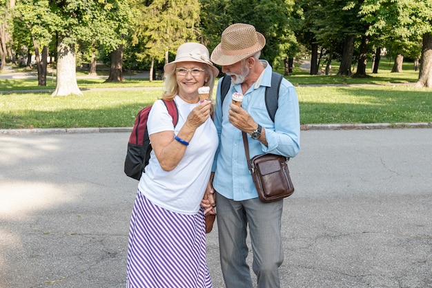 Foto gratuita pareja con helado en la mano caminando por el parque