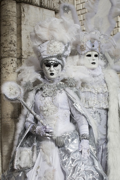 Pareja con hermosos vestidos y máscaras tradicionales de Venecia durante el carnaval de fama mundial