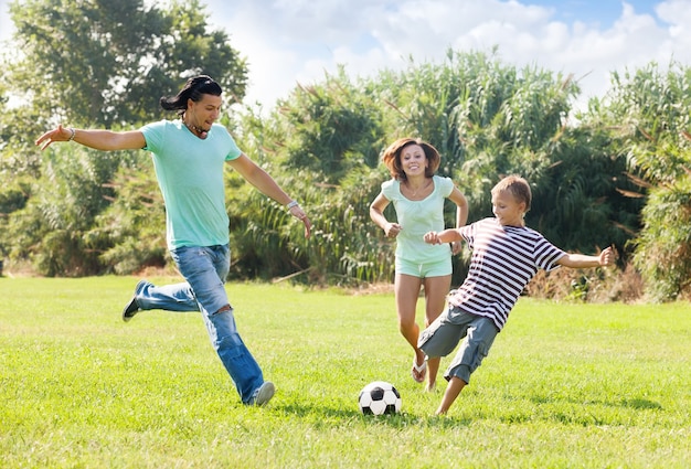 pareja con hijo jugando con balón de fútbol