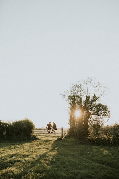 Pareja hipster sentado en una puerta juntos en el campo