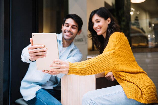 Pareja hispana tomando selfie en tableta