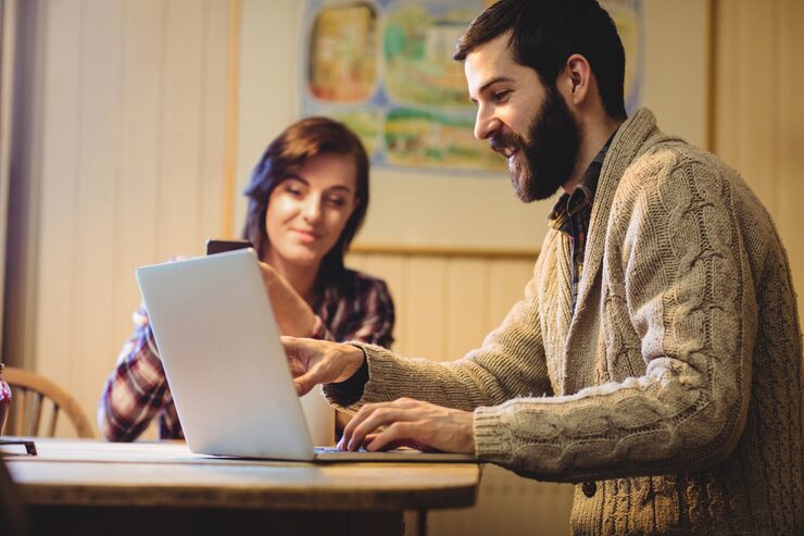 Foto gratuito pareja interactuando mientras usa una computadora portátil y un teléfono móvil