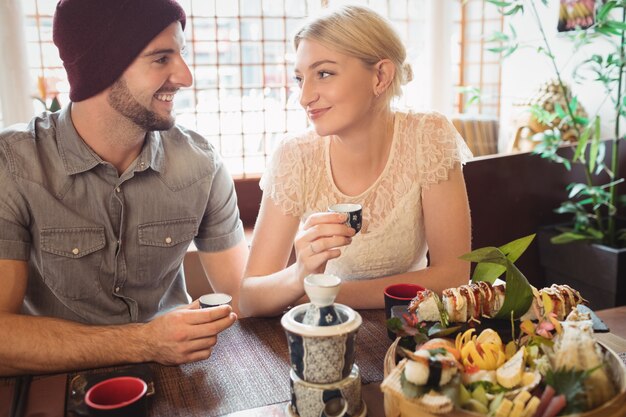 Pareja interactuando entre sí mientras toma el té