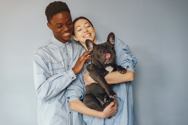 Foto gratuita pareja internacional sobre un fondo azul con un perro