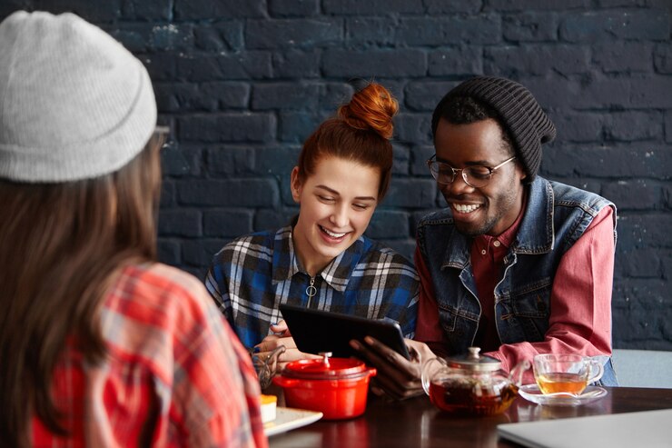 Foto gratuito pareja interracial alegre con conexión inalámbrica a internet gratuita