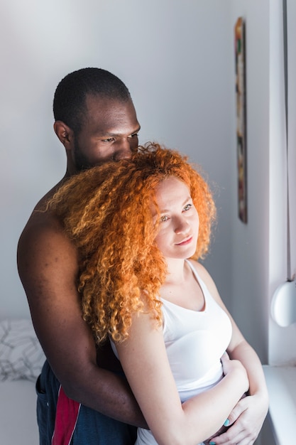 Foto gratuita pareja interracial amorosa en dormitorio