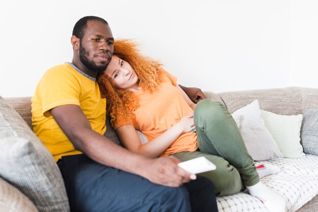 Foto gratuita pareja interracial descansando en un sofa