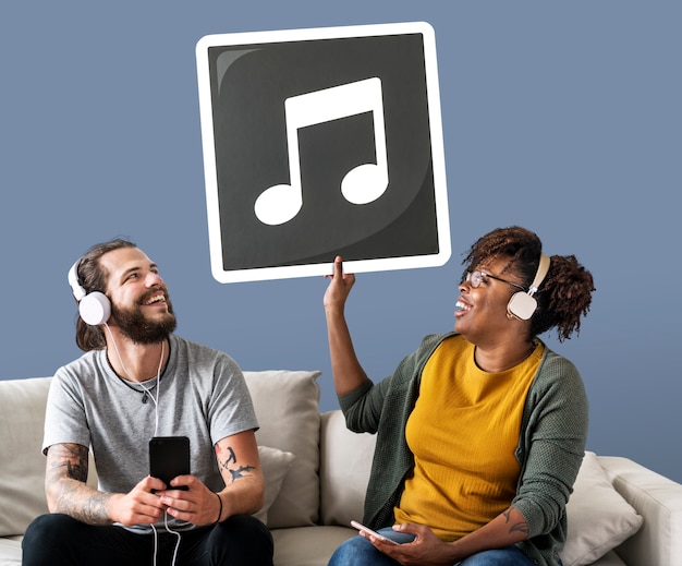 Pareja interracial escuchando música y sosteniendo una nota musical.