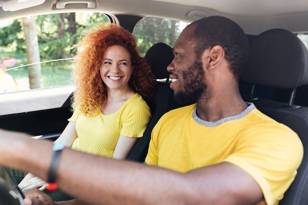 Foto gratuita pareja interracial en un viaje en coche
