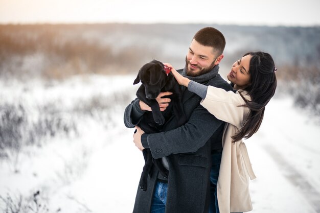 Pareja en invierno en la calle con perro