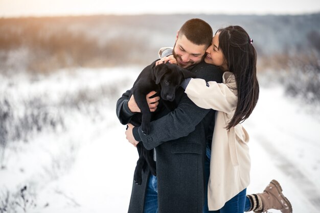 Pareja en invierno en la calle con perro