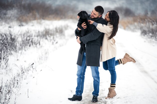 Pareja en invierno en la calle con perro