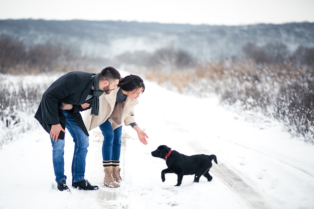 Pareja en invierno en la calle con perro