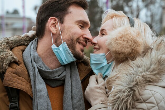 Pareja en invierno con máscaras médicas