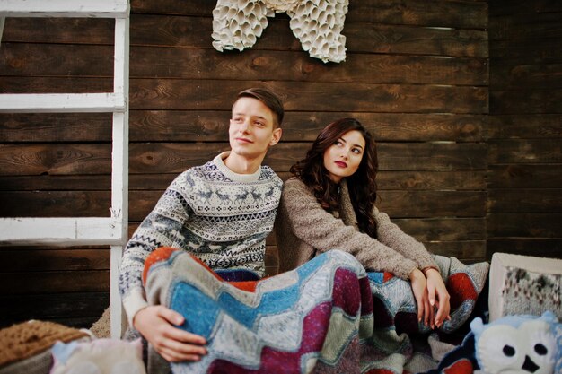 Pareja de invierno de moda joven en fondo de madera