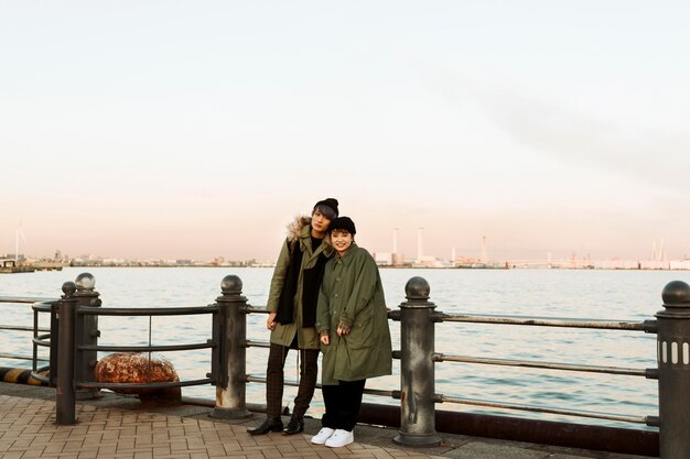 Pareja de invierno de tiro completo posando al aire libre