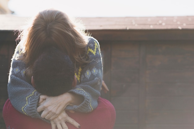 Foto gratuita pareja irreconocible abrazar en la pared de madera