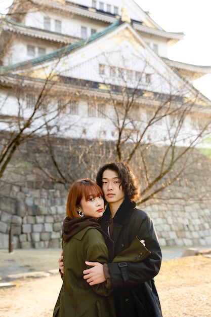 Pareja japonesa abrazándose al aire libre en el día blanco